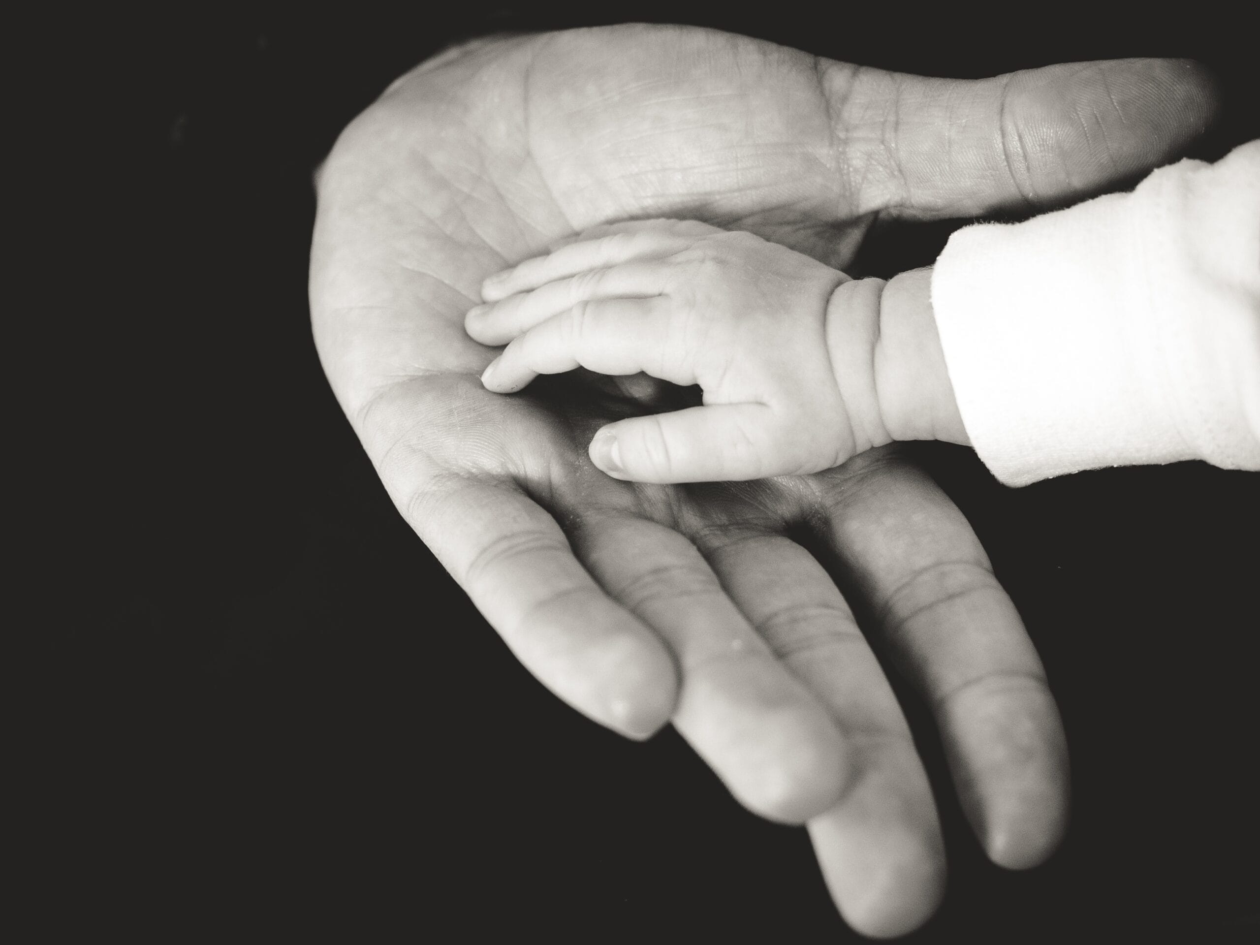 Image of a young hand in an old one